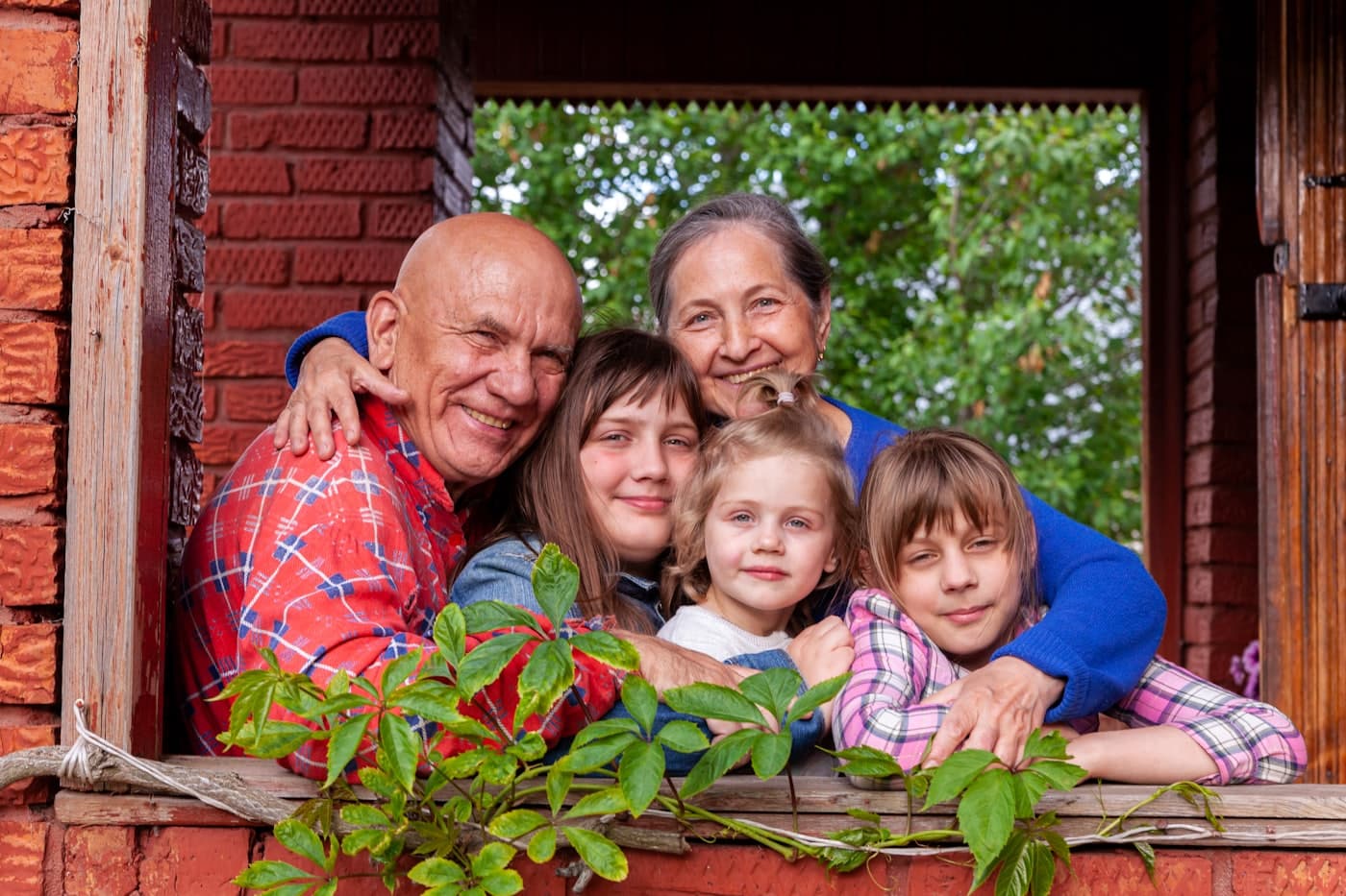A foster family smiling together outdoors